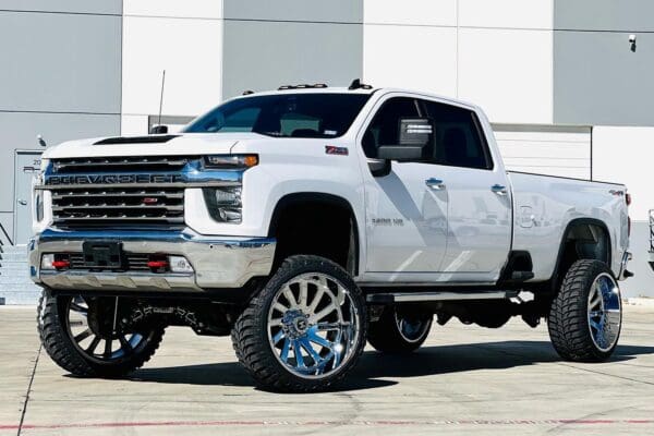 White Chevrolet Silverado pickup truck with chrome wheels.