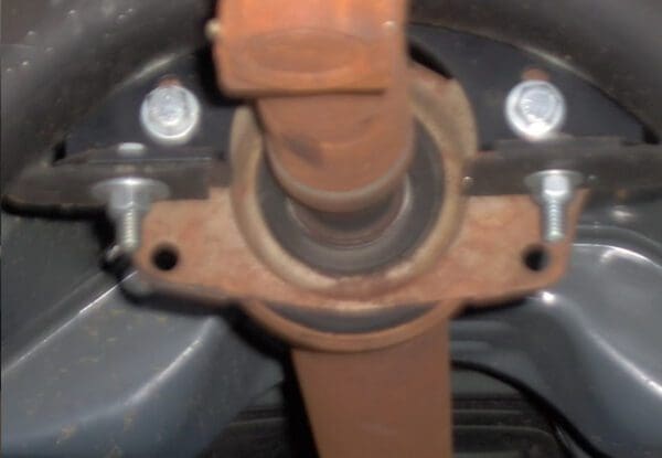 Car axle with bolts and brackets.