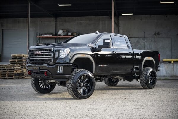 Black GMC pickup truck with large tires.