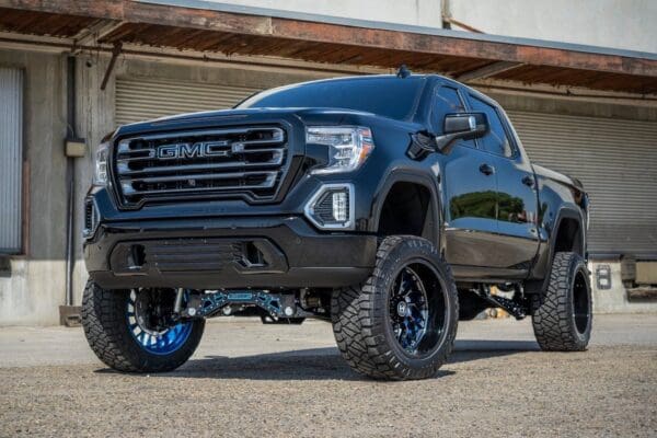 Black GMC pickup truck with large wheels.