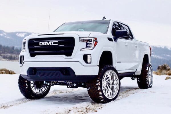 White GMC Sierra pickup truck in snow.