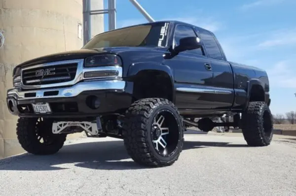 Black GMC Sierra pickup truck with large tires.