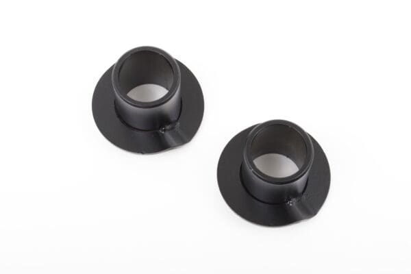 Two black metal spacers for a vehicle.