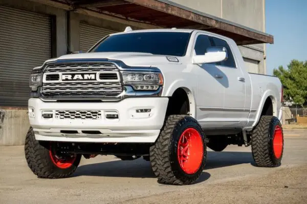 White Ram pickup truck with red rims.