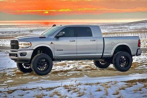 Silver Ram pickup truck in snowy field.