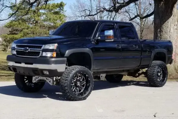 Black Chevrolet Silverado pickup truck with large wheels.