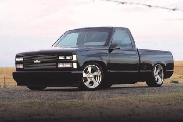 Black pickup truck parked on road.