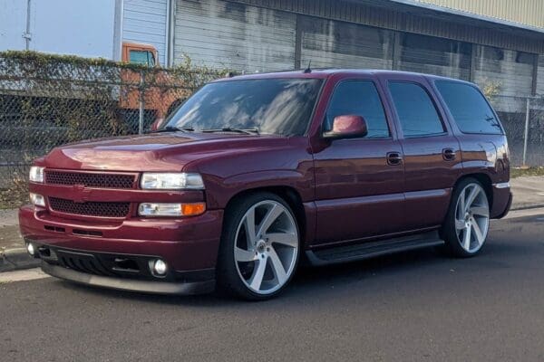 Red Chevrolet Suburban with custom wheels.