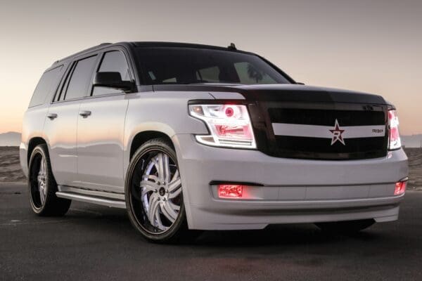 White SUV with custom rims and red star.