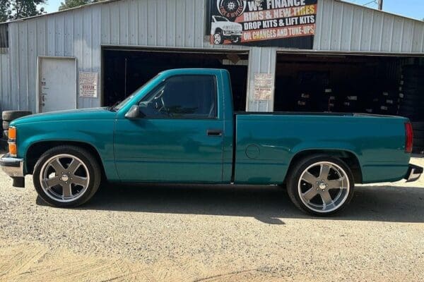 Teal pickup truck with chrome wheels.