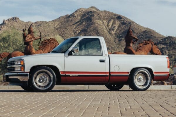 White pickup truck with red stripe.