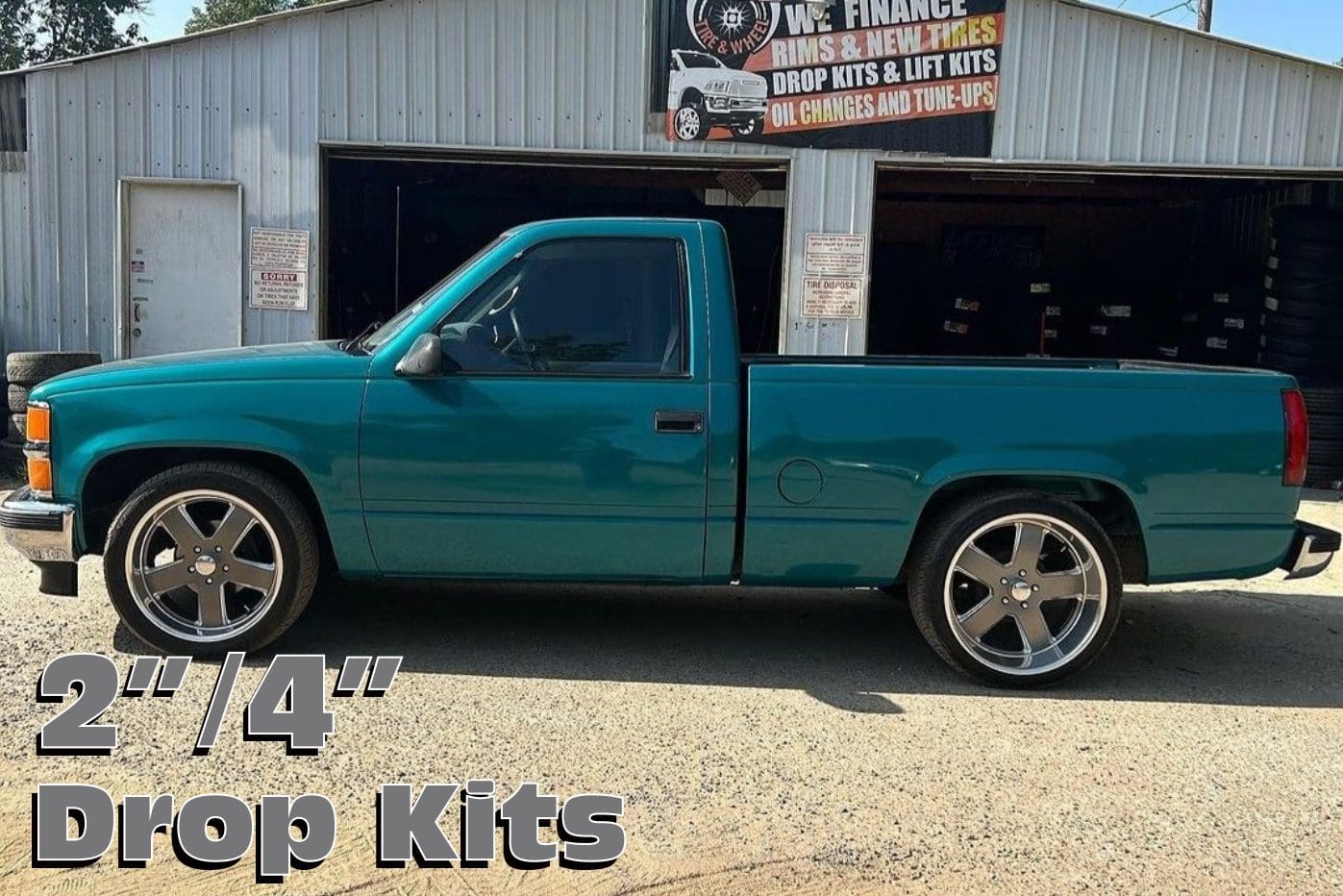 Teal pickup truck with drop kits.