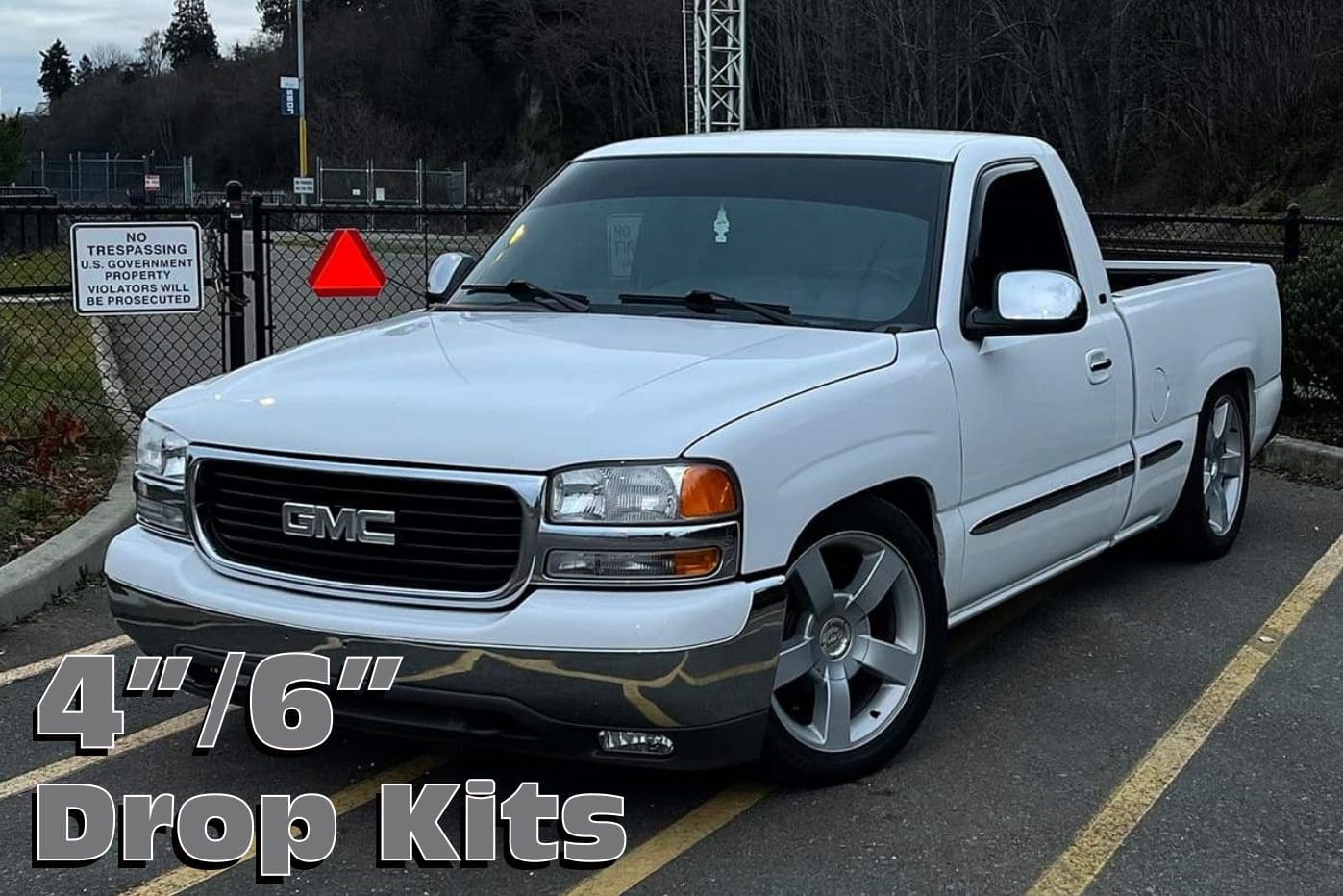 White GMC pickup truck with drop kits.