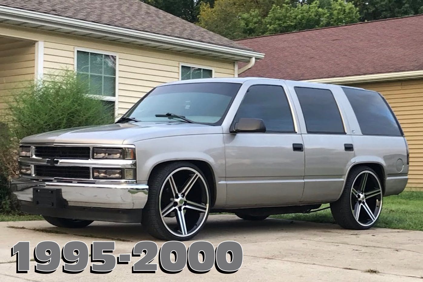 Silver Chevrolet Suburban with custom rims.