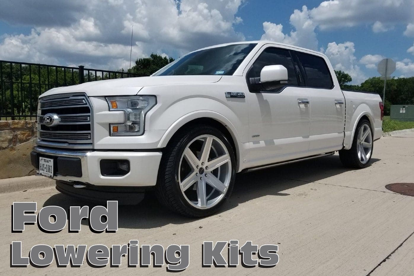 White Ford F-150 truck with lowering kit.