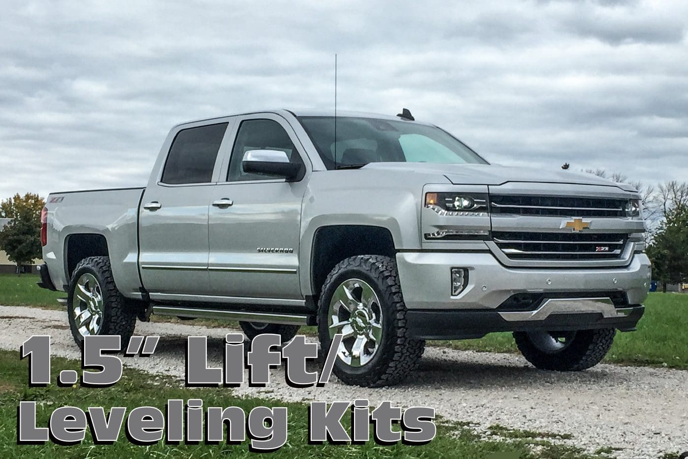 Silver Chevrolet Silverado pickup truck with lift kit.