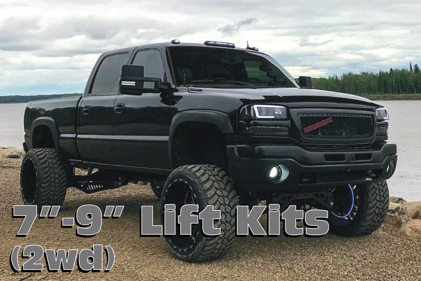 Black truck with lift kit on gravel.