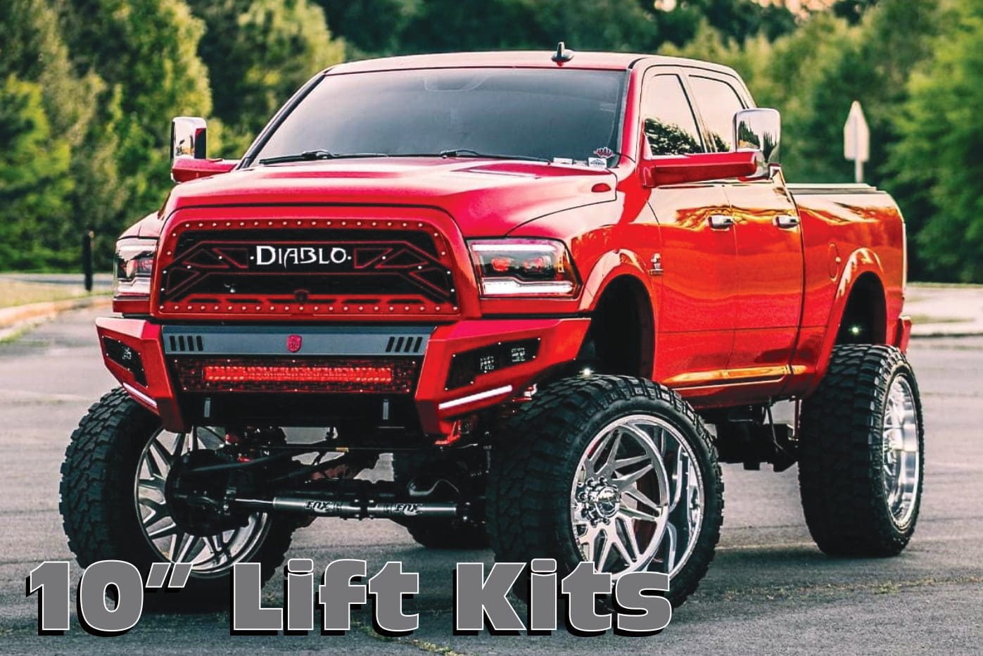 A red truck with large tires and big wheels.