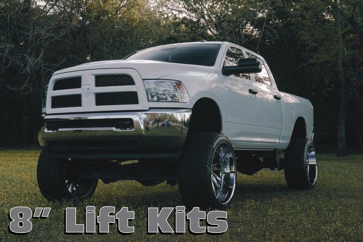 A white truck with large tires is parked in the grass.