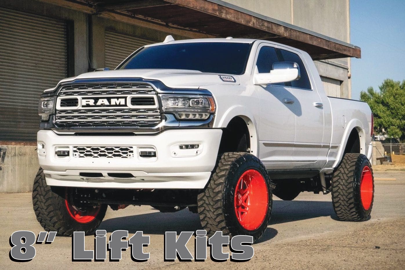 A white truck with red wheels parked in front of a building.