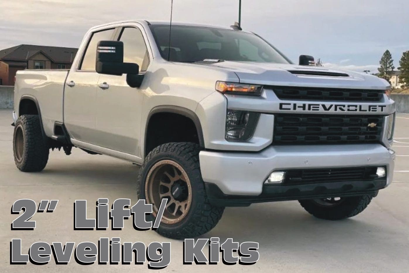 Silver Chevrolet truck with 2" lift kit.