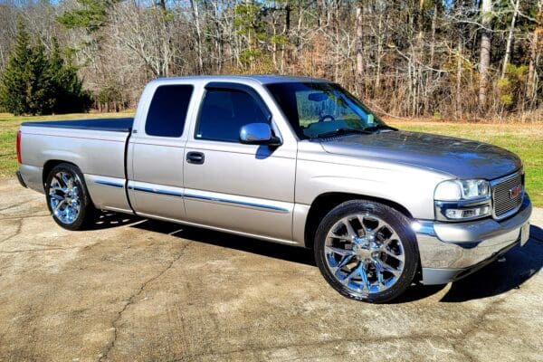 A silver truck parked in the driveway of a house.