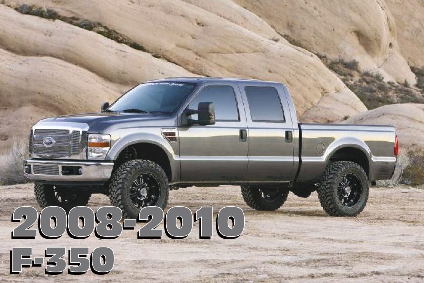 A silver truck is parked on the side of a hill.